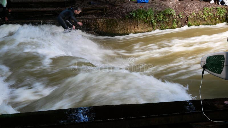Munich allemagne 8 juillet 2024 : vagues sur la rivière eisbach à l'entrée du garten englischer et surfer sur eux banque de vidéos