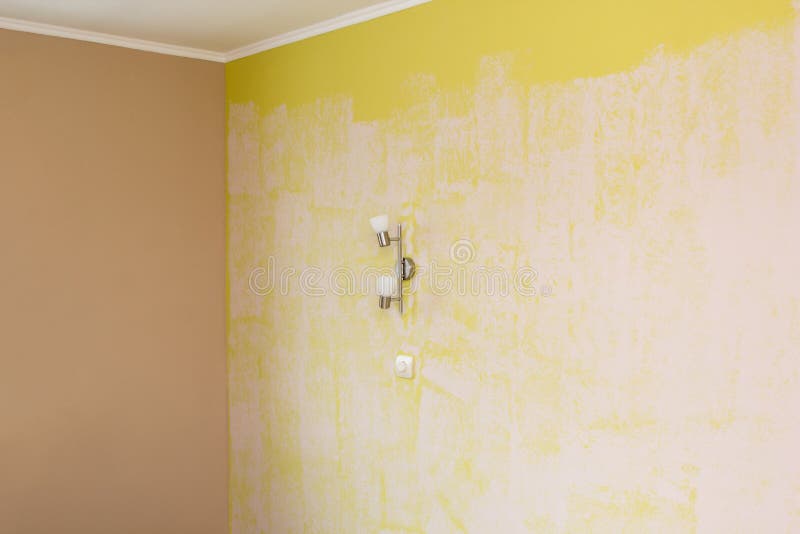 Mur Jaune Peint Dans Le Blanc Avec Le Rouleau De Peinture Photo stock
