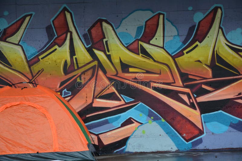 A homeless person`s orange tent becomes part of a mural on a building`s loading dock in Portland, Oregon. A homeless person`s orange tent becomes part of a mural on a building`s loading dock in Portland, Oregon.