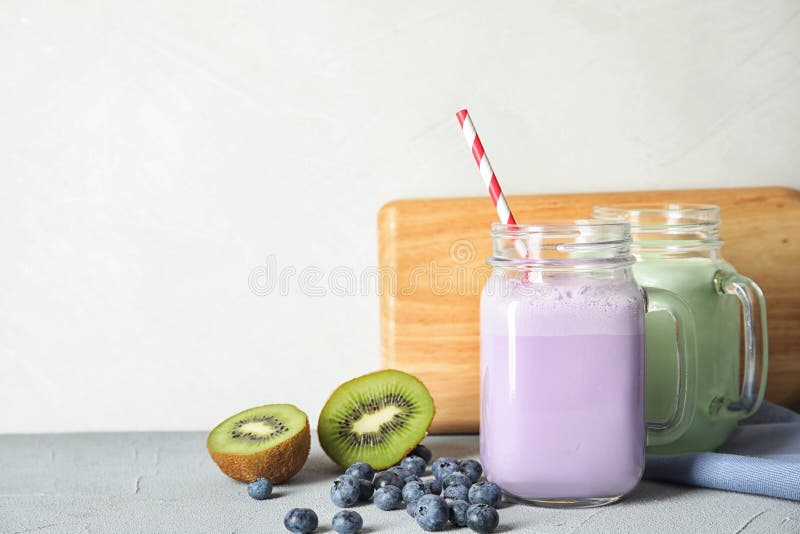 Murarekrus med läckra milkshakar och ingredienser på tabellen royaltyfri fotografi