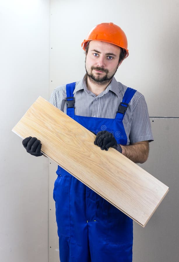 Muratore con tavola di pavimento laminata immagini stock libere da diritti Muratore con tavola di pavimento laminata immagini stock libere da diritti