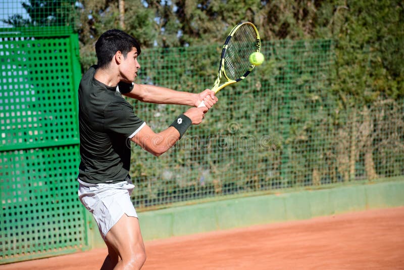 Murcia, Spain, December 26, 2019: Young sportsman training at a tennis clay court in Murcia