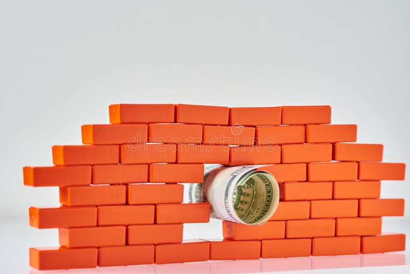 Muro di mattoni rotto con una banconota in dollari in foro Concepte di finanza e di affari fotografie stock Muro di mattoni rotto con una banconota in dollari in foro Concepte di finanza e di affari fotografie stock