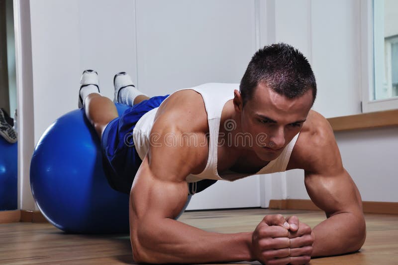 Muscle man excercise with blue ball