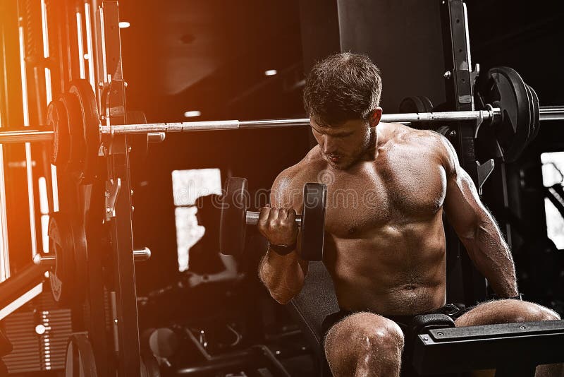 Musculaire bodybuilder oefeningen doen met dumbbels in de gym. atletisch lichaam gezonde levensstijl fitness - motivatie