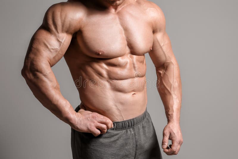 Muscular bodybuilder on grey background