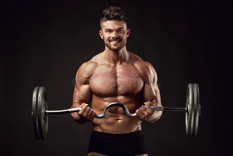 Muscular bodybuilder guy doing exercises with big dumbbell over black background