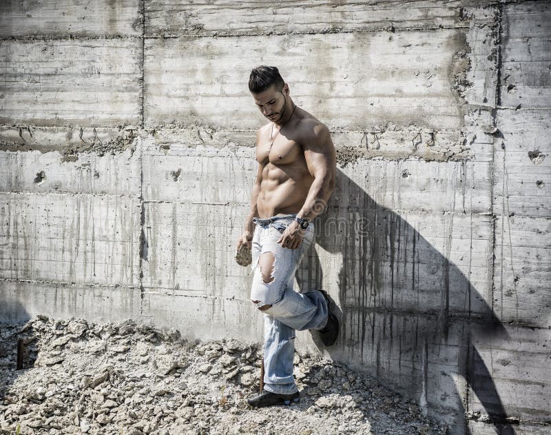 Muscular construction worker shirtless in building. 