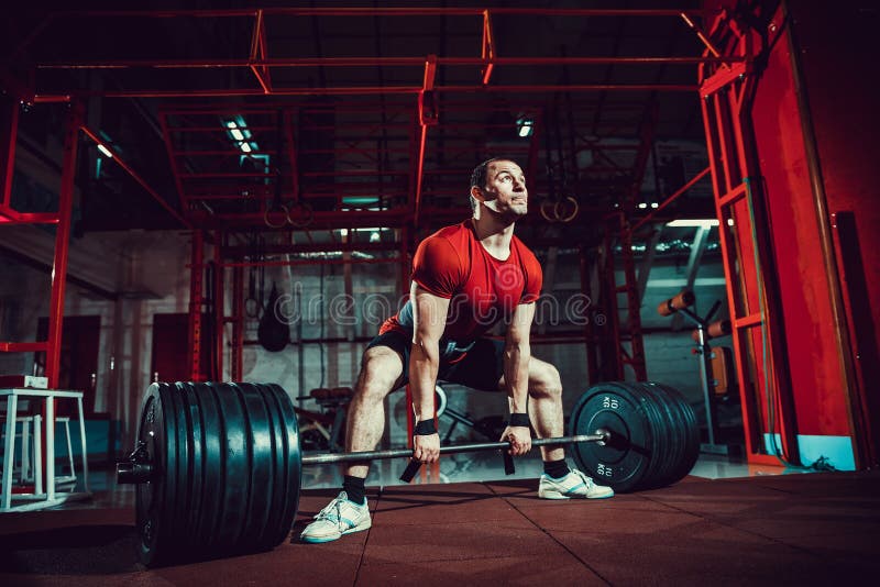 Muscular fitness man doing deadlift a barbell in modern fitness center. Functional training. royalty free stock image Muscular fitness man doing deadlift a barbell in modern fitness center. Functional training. royalty free stock image