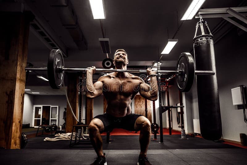 Muscular fitness man doing deadlift a barbell over his head in modern fitness center. Functional training. exercise