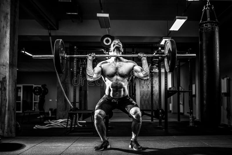 Muscular fitness man doing deadlift a barbell over his head in modern fitness center. Functional training. exercise