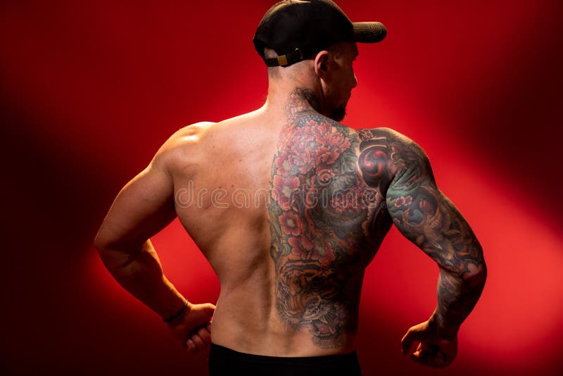 Muscular and Huge Back with Typical Bodybuilding Pose. Bodybuilder with  Tattoo in Cap on Red Background Stock Image - Image of exercise, body:  182023883