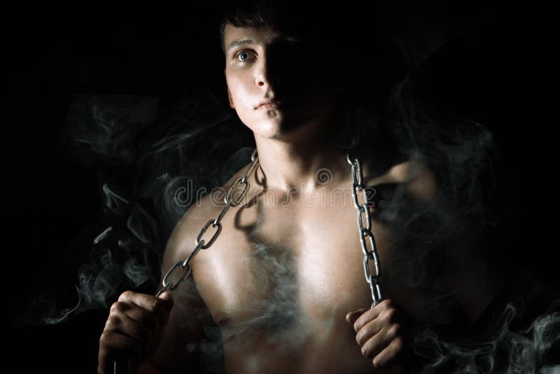 Muscular man with chain and smoke royalty free stock photo
