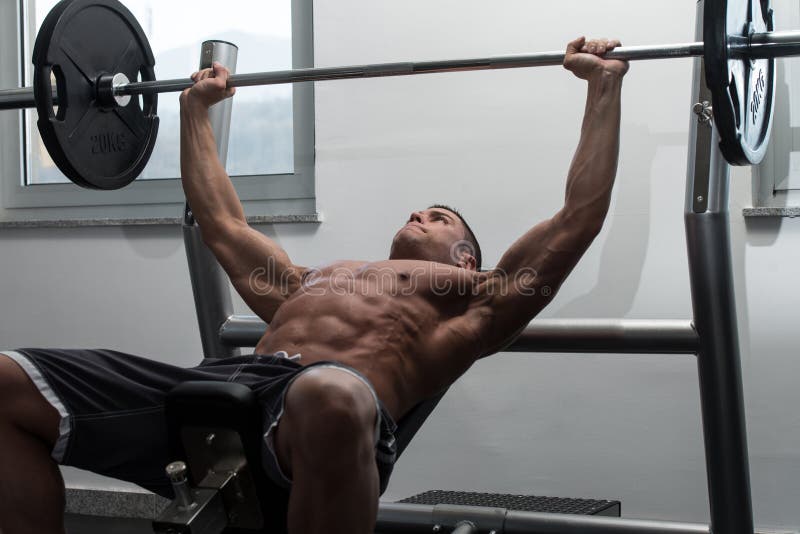 Muscular Man Doing Bench Press Exercise for Chest Stock Photo Image