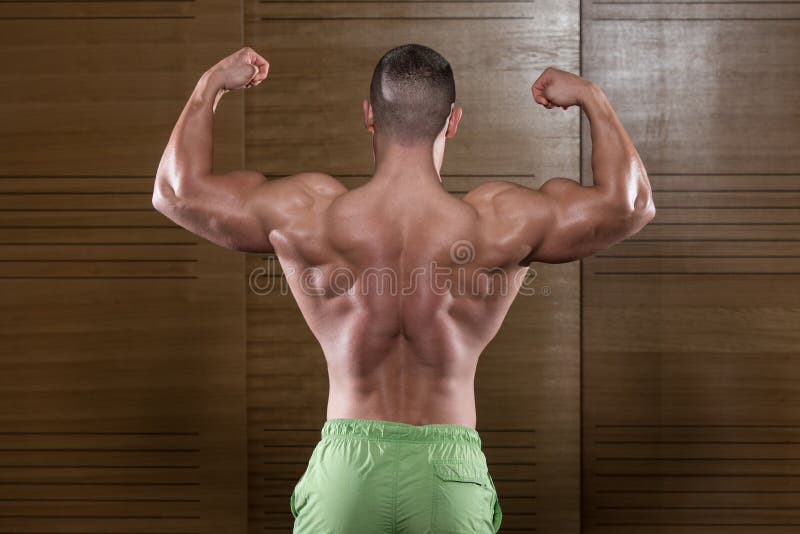 Muscular Man Flexing Back Muscles Pose. Health, athlete.