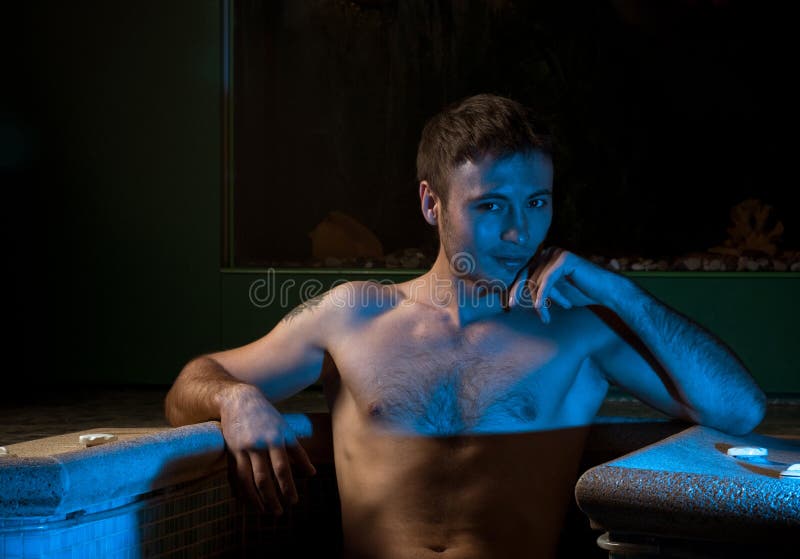 Muscular man posing in the swimming pool