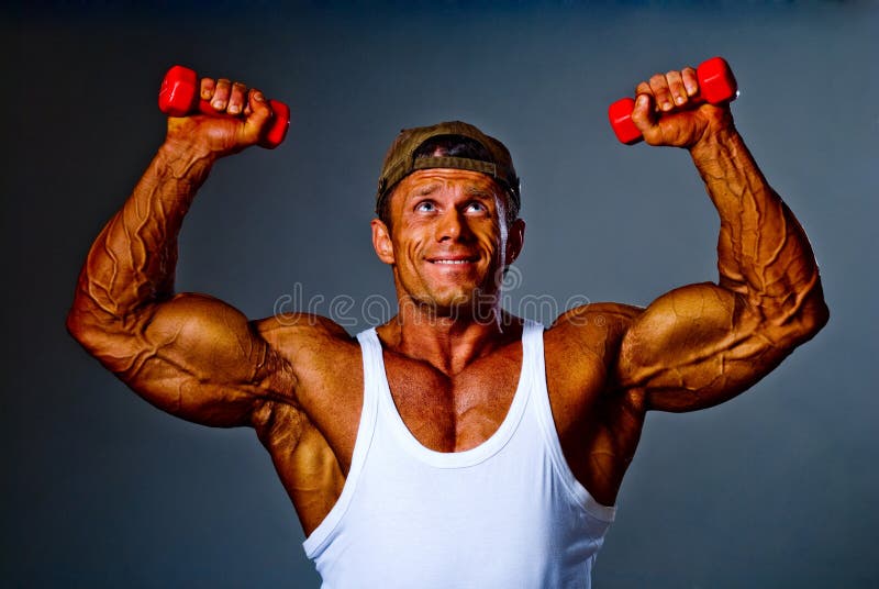 Muscular man training with small dumbbells