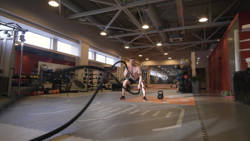 Muscular Man Training Workout Exercise With Ropes In Fitness