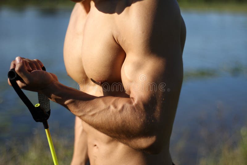 Muscular super-high level man pulls rubber bands imagem de stock royalty free Muscular super-high level man pulls rubber bands imagem de stock royalty free
