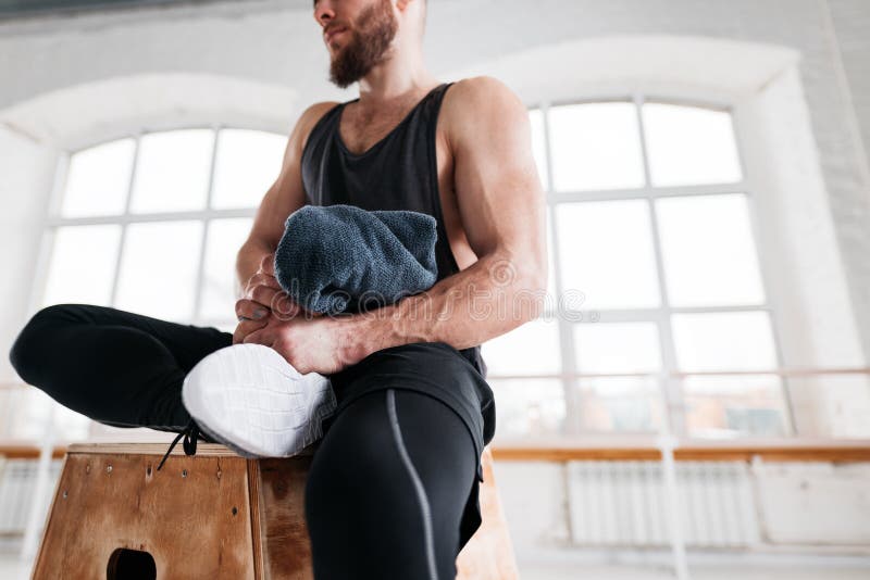 Perspiring fit athlete relaxing in sport gym after intense workout stock photo Perspiring fit athlete relaxing in sport gym after intense workout stock photo