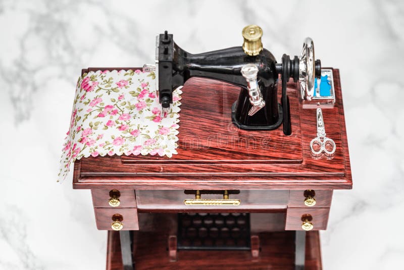Close up view of an old Singer treadle sewing machine with thread on the  bobbin, held together with rope but still working Stock Photo - Alamy