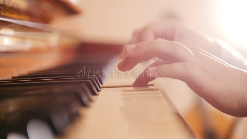 Music lesson. Girl playing piano. Close up on piano keys, child hands.