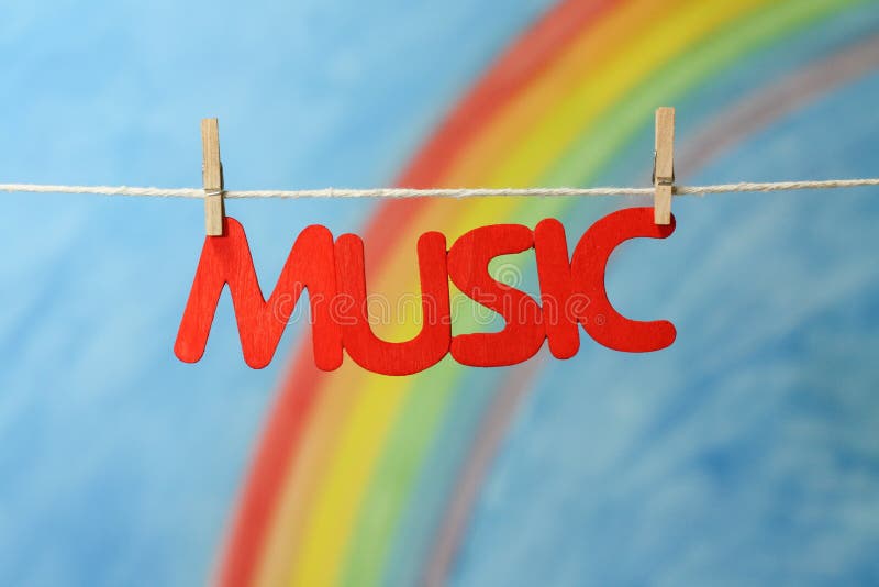 The word music with a colorful rainbow and blue sky background