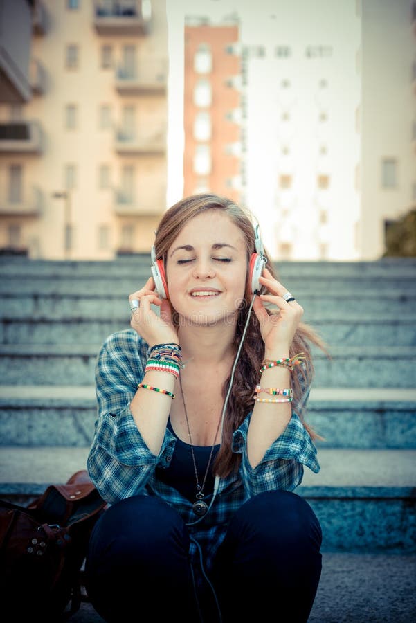 Musica d'ascolto della bella giovane donna bionda dei pantaloni a vita bassa immagini stock Musica d'ascolto della bella giovane donna bionda dei pantaloni a vita bassa immagini stock