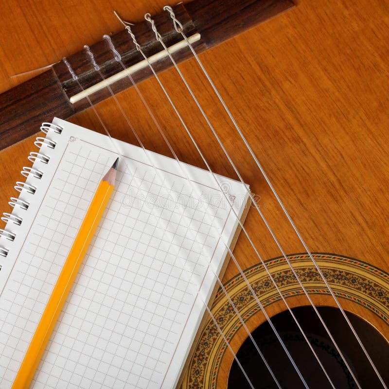 Musical Instruments the Acoustic Guitar and a Notebook. Stock Image
