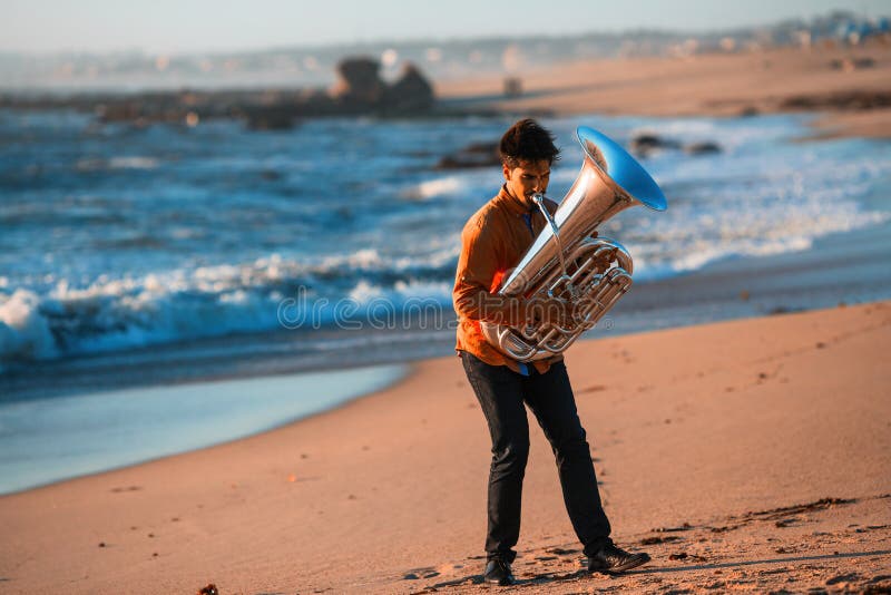 Lone musician instrumentalist playing the Tuba on the sea coast.