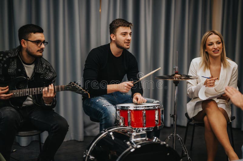 Musicians practicing and collaborating with instruments and notes in a studio environment, preparing for performance.