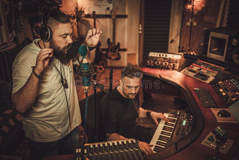 Musicians recording vocal and keyboards in boutique recording studio. royalty free stock photo Musicians recording vocal and keyboards in boutique recording studio. royalty free stock photo