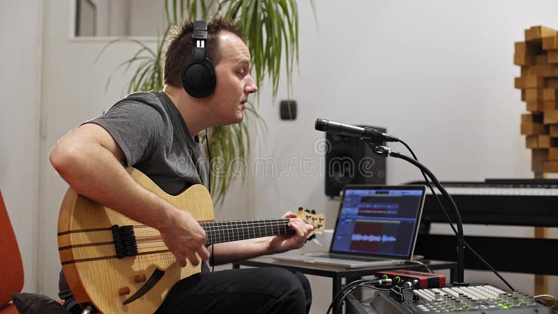 Musicien chantant et jouant la guitare ?lectrique dans le studio ? la maison de musique