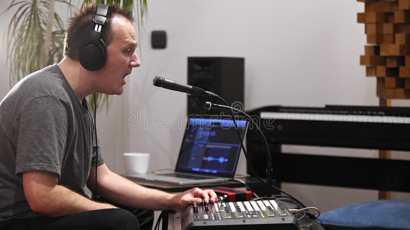 Musicien chantant et jouant le clavier du Midi dans le studio à la maison de musique