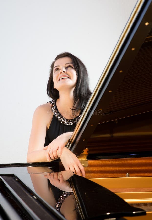 Musicien de sourire par le grand piano photos stock Musicien de sourire par le grand piano photos stock