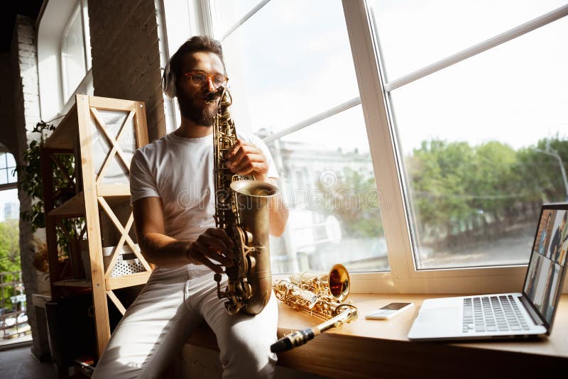Musicista caucasico che suona sassofono durante un concerto a casa e ha messo in quarantena un imponente improvvisazione con la ba