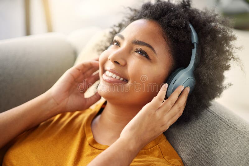 Musik och radio med en tjej på soffan för att slappna av i lägenheten med leende på helgen. låtkvinna och ligger på arkivbild