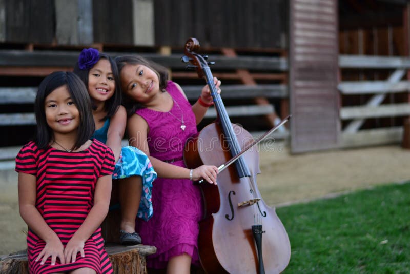 Little Girl playing cello with cousins. Little Girl playing cello with cousins