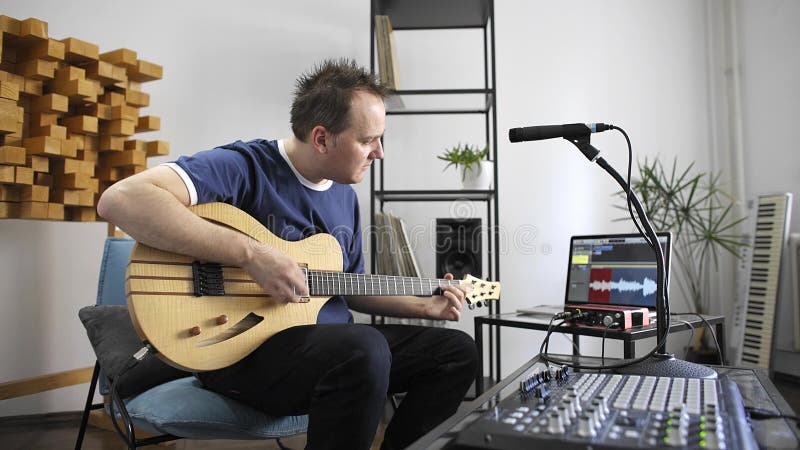 Musiker som spelar den elektriska gitarren i hem- musikstudio