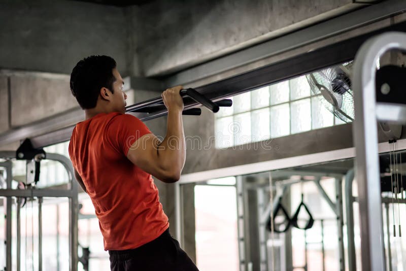 Strong muscular athletic Asian man perform bodybuilding by pulling up on horizontal bar at sport gym. Hands, arms, shoulder workout. Bodybuilding and healthy lifestyle concept, active, adult, athlete, back, background, biceps, bodybuilder, chest, coach, exercise, fit, fitness, guy, handsome, male, muscle, nutrition, pack, person, power, protein, pullup, reflect, sexy, sportsman, strength, torso, trainer, training, triceps, waist, weight, young. Strong muscular athletic Asian man perform bodybuilding by pulling up on horizontal bar at sport gym. Hands, arms, shoulder workout. Bodybuilding and healthy lifestyle concept, active, adult, athlete, back, background, biceps, bodybuilder, chest, coach, exercise, fit, fitness, guy, handsome, male, muscle, nutrition, pack, person, power, protein, pullup, reflect, sexy, sportsman, strength, torso, trainer, training, triceps, waist, weight, young