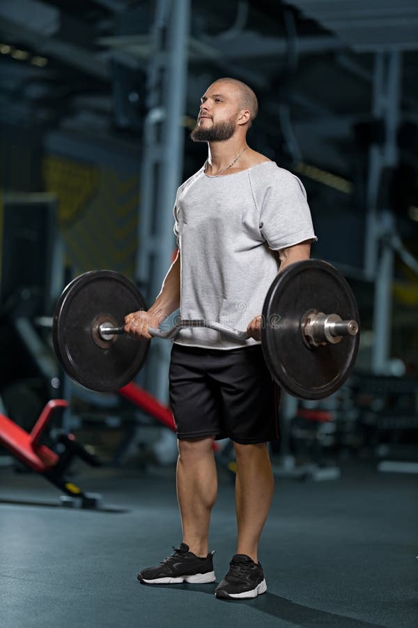 Muskelmanövrer med barbell vid biceps fotografering för bildbyråer