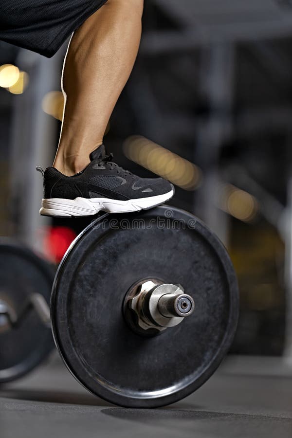 Muskulärt ben till en kroppsbyggare i en svart smyg på gymmet royaltyfria foton