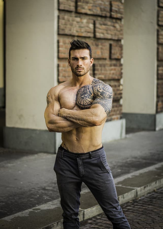 Handsome muscular shirtless man with tattoo posing in European city center, Turin, Italy. Handsome muscular shirtless man with tattoo posing in European city center, Turin, Italy