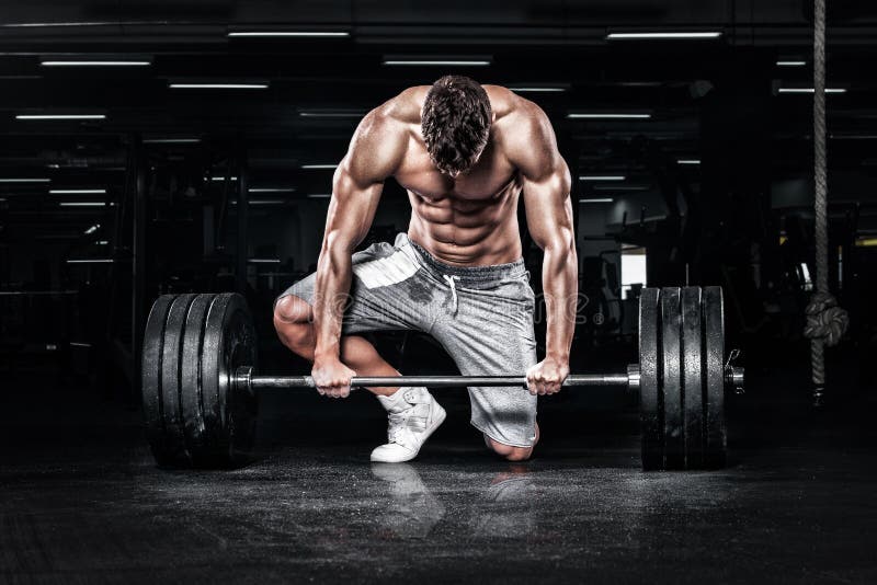 Athletic shirtless young sports man - fitness model with barbell in gym. Athletic shirtless young sports man - fitness model with barbell in gym.