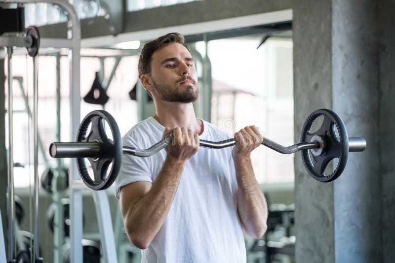 Muskul?ser Bodybuilderkerl, der ?bungen mit Gewichtheben Barbell in der Turnhalle tut Eignungs-Manntraining des Sports junges arb lizenzfreie stockfotos Muskul?ser Bodybuilderkerl, der ?bungen mit Gewichtheben Barbell in der Turnhalle tut Eignungs-Manntraining des Sports junges arb lizenzfreie stockfotos