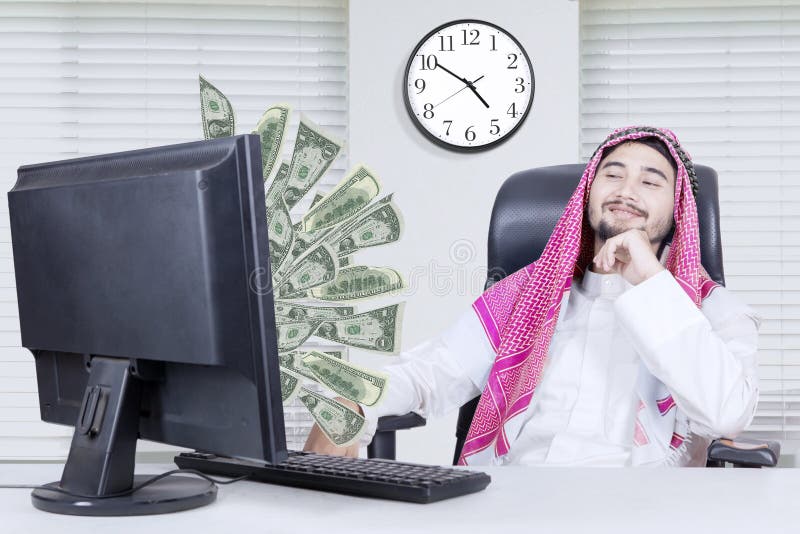 Muslim businessman looking at money stock photo Muslim businessman looking at money stock photo