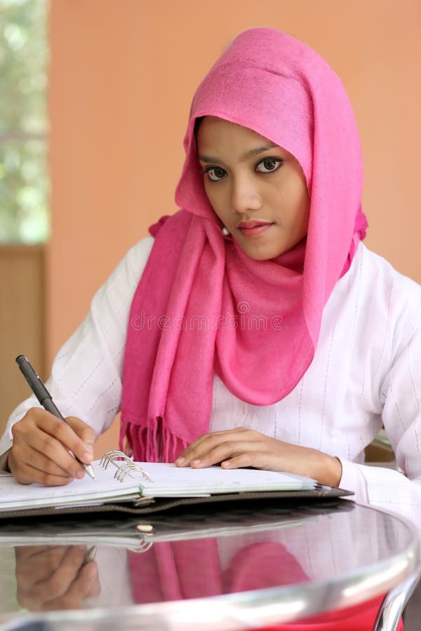 Muslim girls writing a diary book on the table