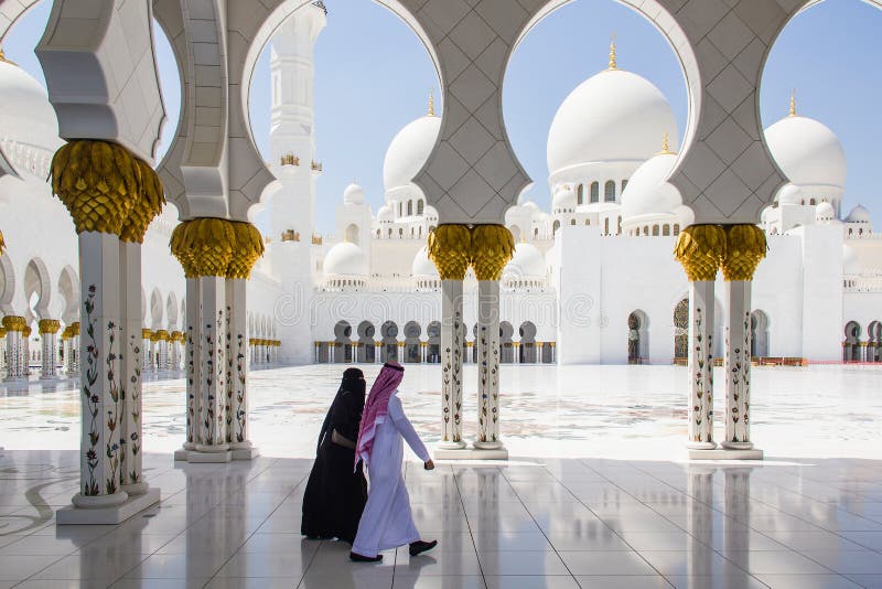 Muslim man and woman walking at Sheikh Zayed Grand Mosque taken on March 31, 2013 in Abu Dhabi, Unit stock images Muslim man and woman walking at Sheikh Zayed Grand Mosque taken on March 31, 2013 in Abu Dhabi, Unit stock images