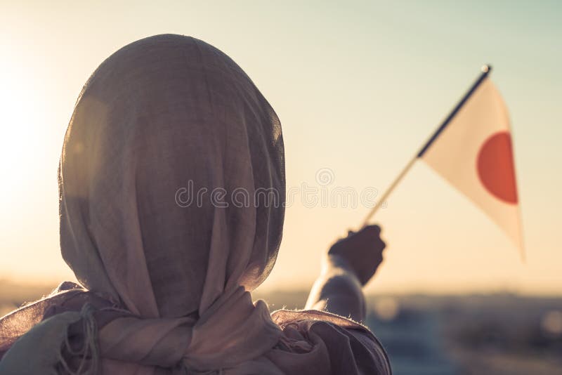 Muslim woman in scarf with Japanese flag of at sunset. Concept. royalty free stock image Muslim woman in scarf with Japanese flag of at sunset. Concept. royalty free stock image