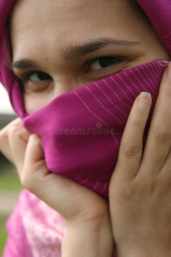 Muslim woman smiling and hiding her face